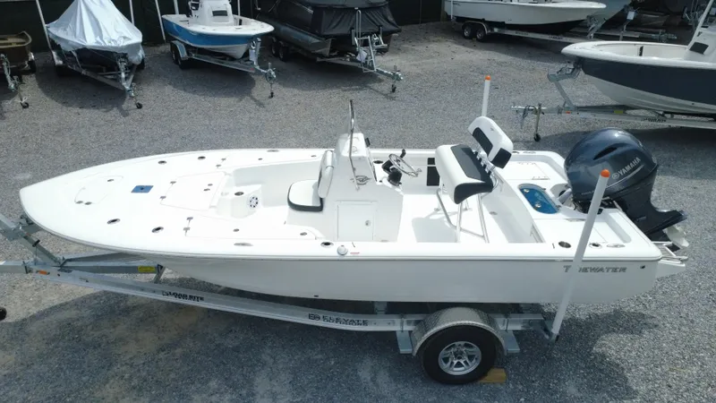 Slide: The Image of 2025 Tidewater 1910 Bay Max boat on trailer in a gravel lot. - 1