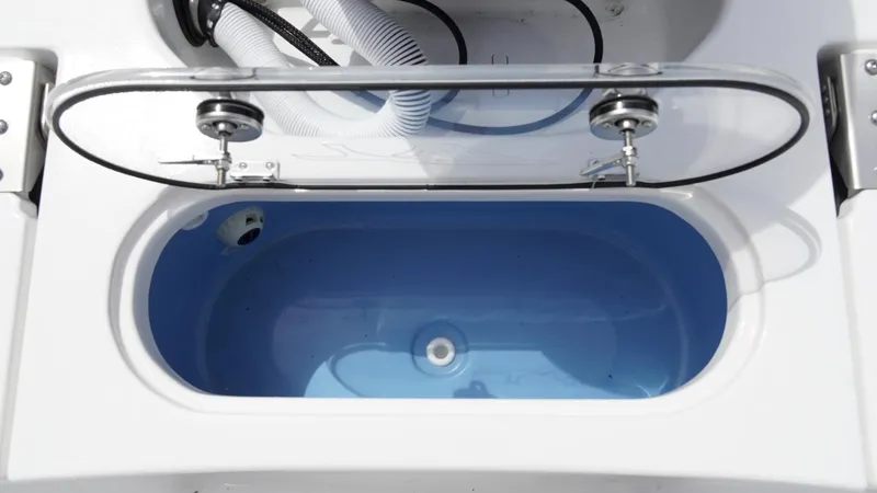 Slide: The Image of Livewell compartment in 2025 Tidewater 1910 Bay Max boat, featuring a blue interior and clear lid. - 16
