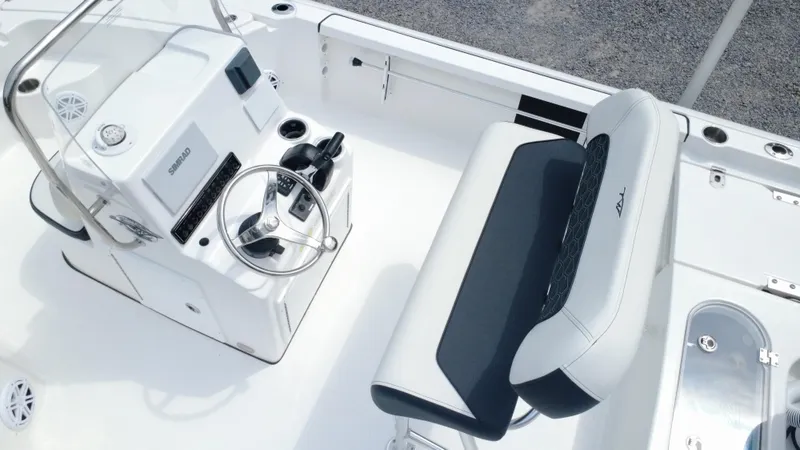 Slide: The Image of 2025 Tidewater 1910 Bay Max boat interior with steering console and cushioned seating. - 20