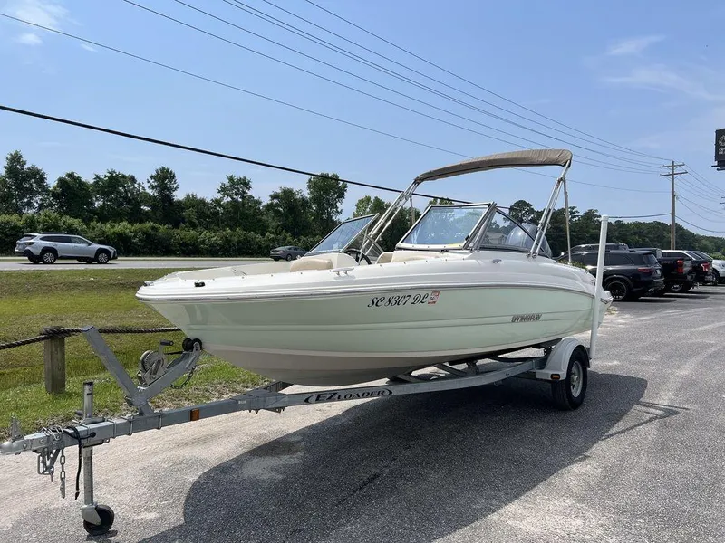 Slide: The Image of 2019 Stingray 191DC (OB) boat on trailer, parked outdoors on a sunny day. - 10