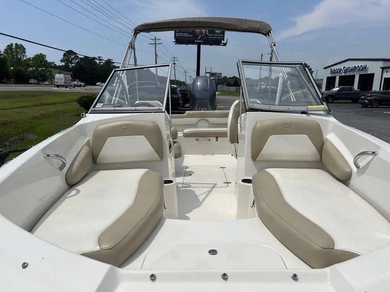 Slide: The Image of 2019 Stingray 191DC (OB) boat with beige seating and open deck, parked outdoors. - 3