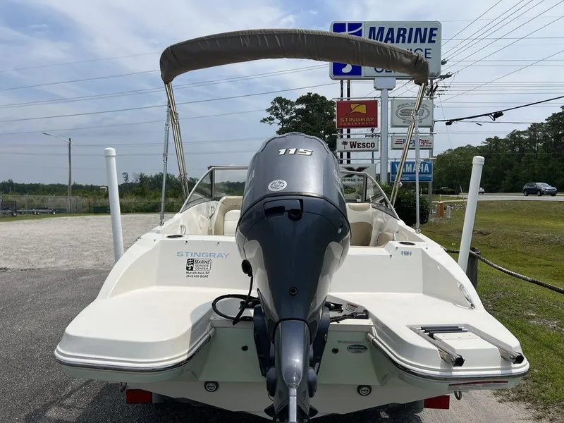 Slide: The Image of 2019 Stingray 191DC (OB) boat with outboard motor, parked near marine dealership. - 4