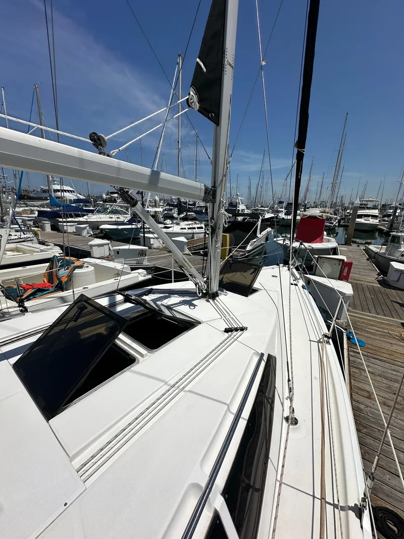 Slide: The Image of 2013 Hunter 33 sailboat docked at marina under clear blue sky. - 10