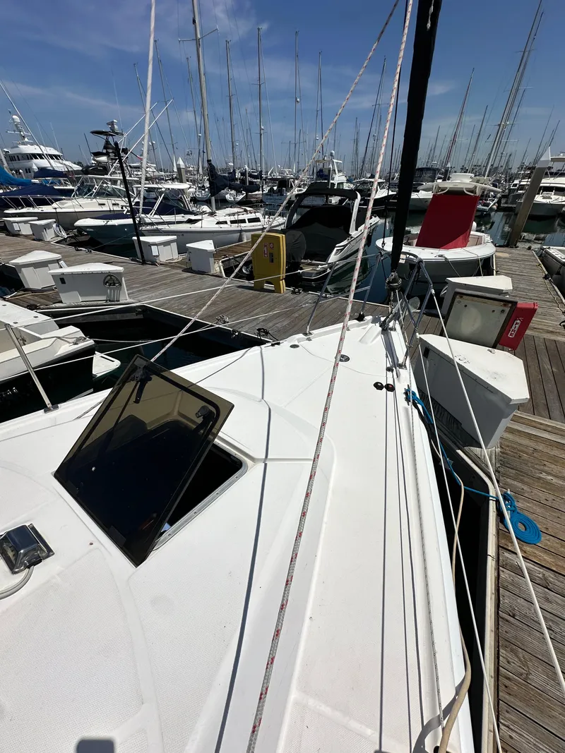 Slide: The Image of 2013 Hunter 33 sailboat docked at a marina with other boats. - 11
