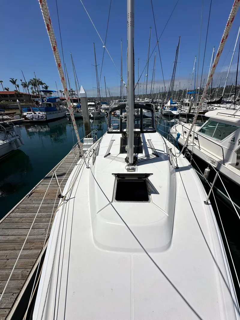 Slide: The Image of 2013 Hunter 33 sailboat docked at marina, clear sky, surrounded by other boats. - 15