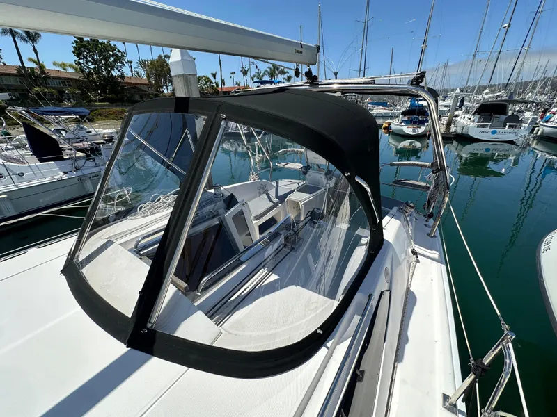 Slide: The Image of 2013 Hunter 33 sailboat with black canopy docked in marina. - 18