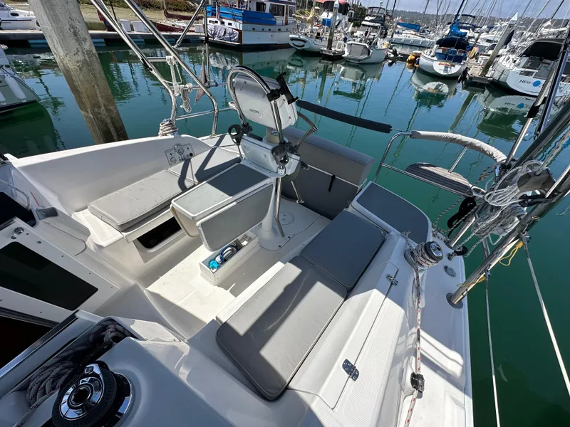 Slide: The Image of 2013 Hunter 33 sailboat cockpit with seating, steering wheel, and marina view. - 20