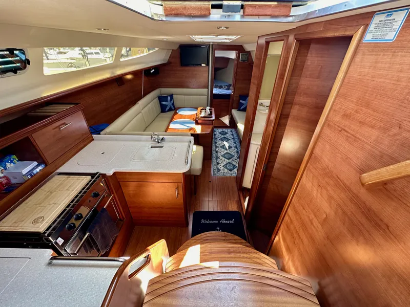 Slide: The Image of Interior of 2013 Hunter 33 sailboat with kitchen, seating, and wood finish. - 32