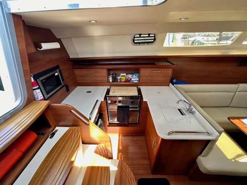 Slide: The Image of Interior of 2013 Hunter 33 sailboat with modern kitchen and seating area. - 34