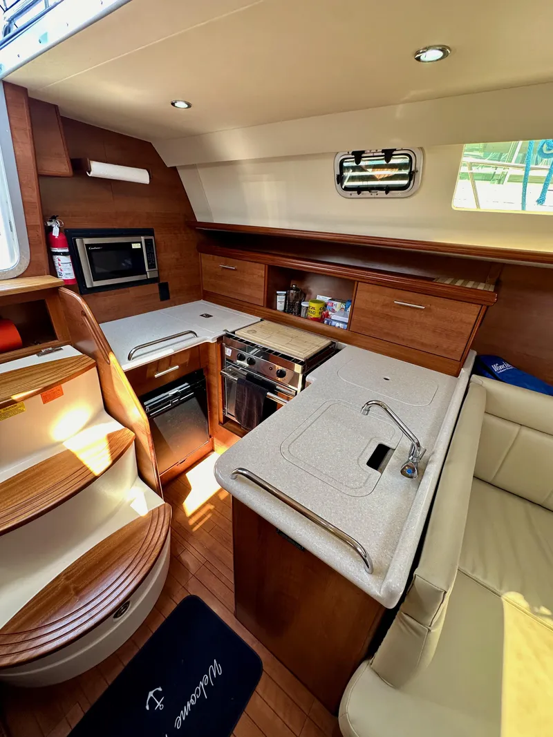 Slide: The Image of Interior of 2013 Hunter 33 sailboat with modern kitchen and seating area. - 35