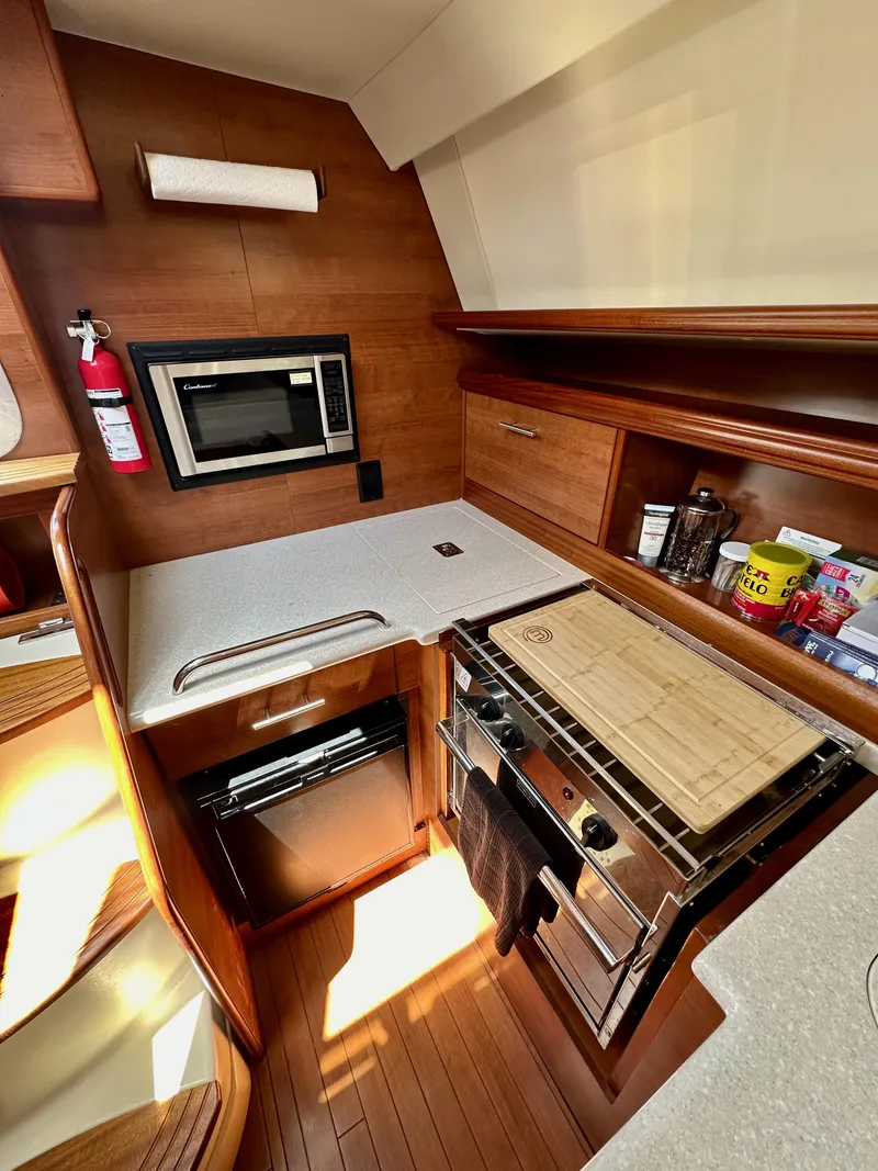 Slide: The Image of 2013 Hunter 33 yacht kitchen with modern appliances and wooden cabinetry. - 36