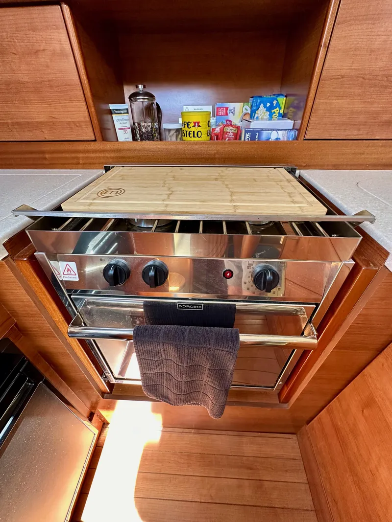 Slide: The Image of Compact kitchen with stainless steel oven, wooden cabinetry, and assorted pantry items on a Hunter 33 yacht. - 37