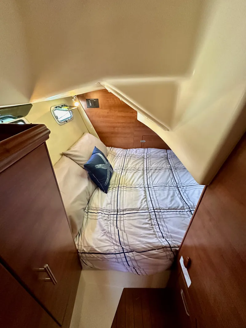 Slide: The Image of 2013 Hunter 33 yacht cabin with cozy bed and wooden interior. - 41