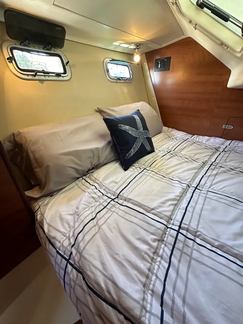 Slide: The Image of Cozy cabin interior of 2013 Hunter 33 sailboat with nautical-themed bedding. - 43