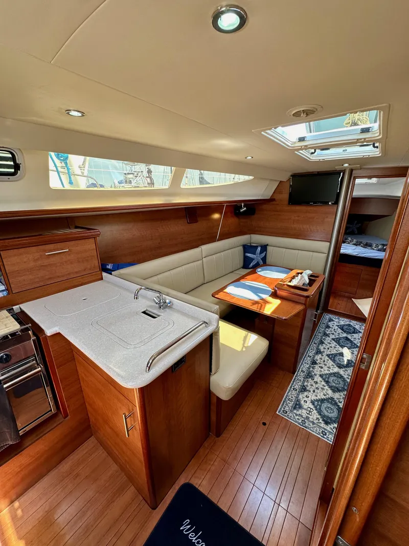 Slide: The Image of 2013 Hunter 33 yacht interior with modern kitchen, dining area, and cozy seating. - 44