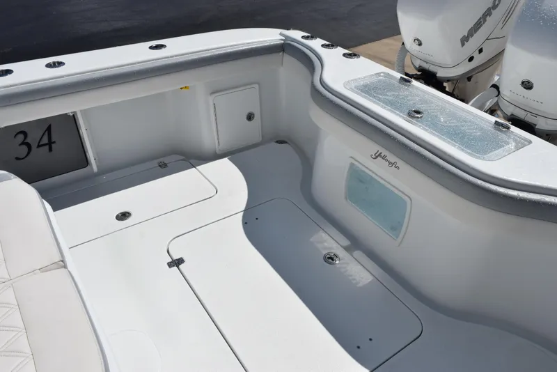 Slide: The Image of 2022 Yellowfin 34 Offshore boat deck with storage compartments and twin outboard motors. - 13