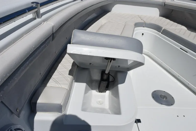 Slide: The Image of 2022 Yellowfin 34 Offshore boat interior with cushioned seating and storage compartment. - 18