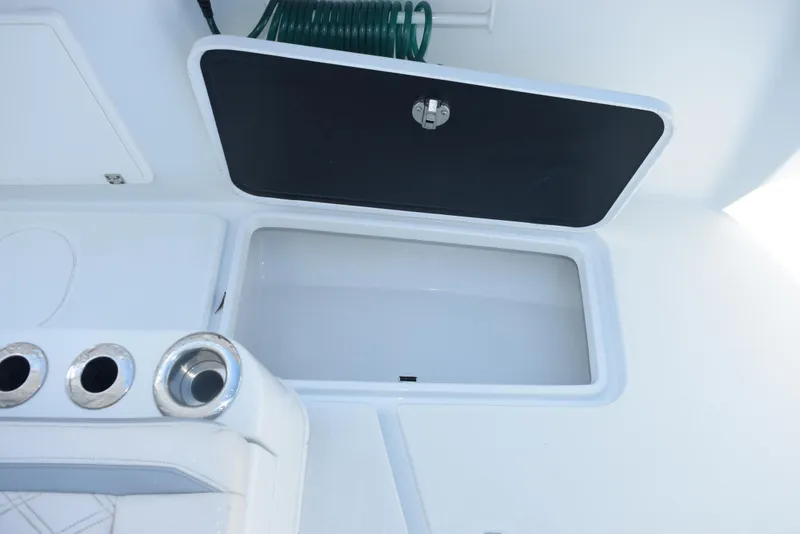 Slide: The Image of 2022 Yellowfin 34 Offshore boat storage compartment with open lid and hose. - 23