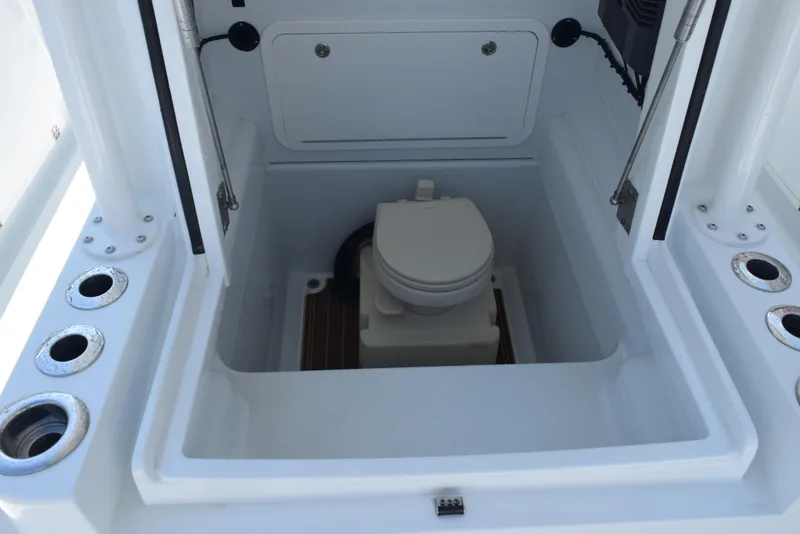 Slide: The Image of 2022 Yellowfin 34 Offshore boat toilet compartment with rod holders and storage. - 25