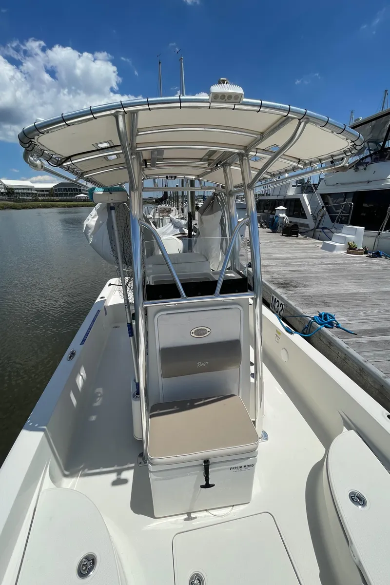 Slide: The Image of 2012 Ranger 2410 Bay Ranger boat with T-top, docked under clear blue sky. - 12
