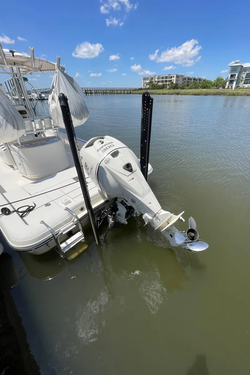 Slide: The Image of 2012 Ranger 2410 Bay Ranger boat docked on calm water under a clear blue sky. - 13