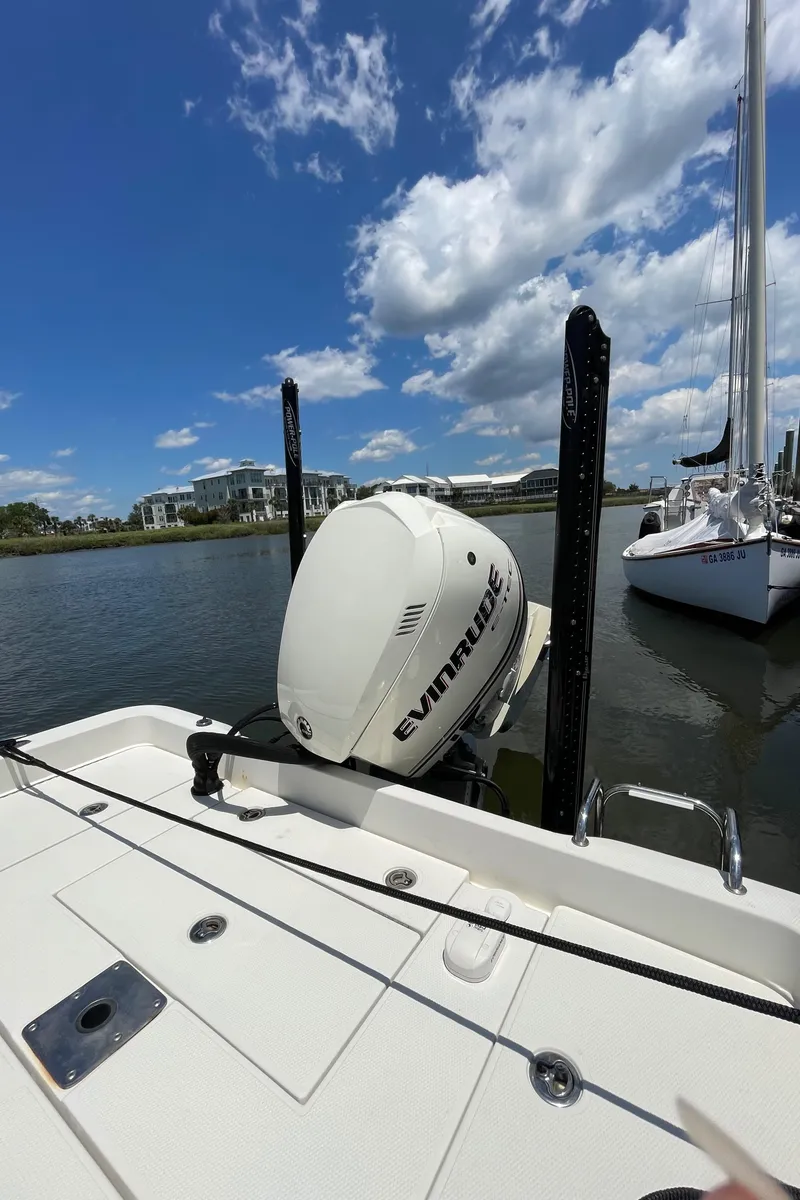Slide: The Image of 2012 Ranger 2410 Bay Ranger boat with Evinrude motor, docked on a sunny day. - 16