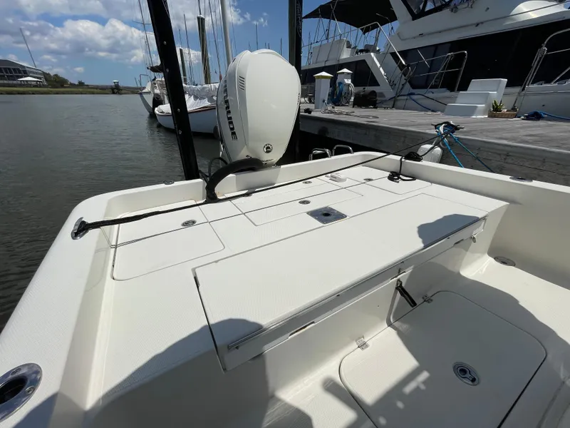 Slide: The Image of 2012 Ranger 2410 Bay Ranger boat docked, showcasing spacious deck and motor. - 18