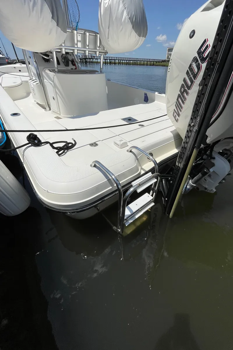 Slide: The Image of 2012 Ranger 2410 Bay Ranger boat with Evinrude motor, docked near a pier. - 19