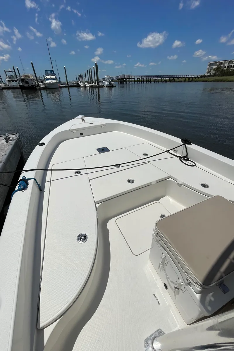 Slide: The Image of 2012 Ranger 2410 Bay Ranger boat docked in a marina under a clear blue sky. - 24