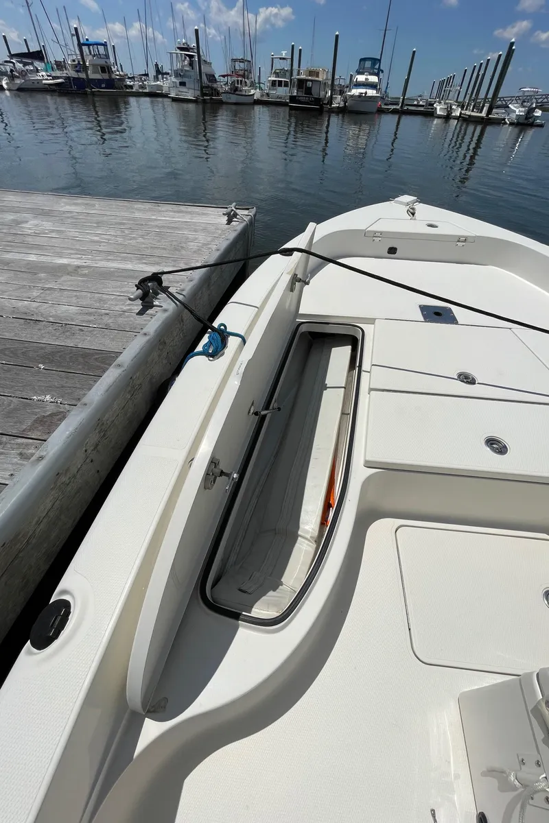 Slide: The Image of 2012 Ranger 2410 Bay Ranger boat docked at marina, open storage compartment visible. - 25