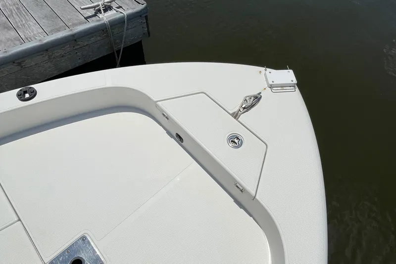 Slide: The Image of 2012 Ranger 2410 Bay Ranger boat bow near dock, featuring clean white deck. - 27
