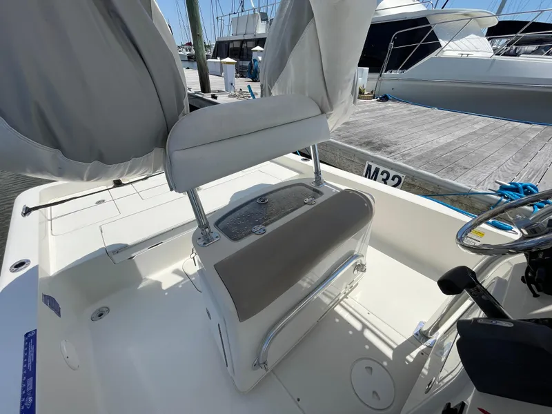 Slide: The Image of 2012 Ranger 2410 Bay Ranger boat interior with seating and console at marina. - 9
