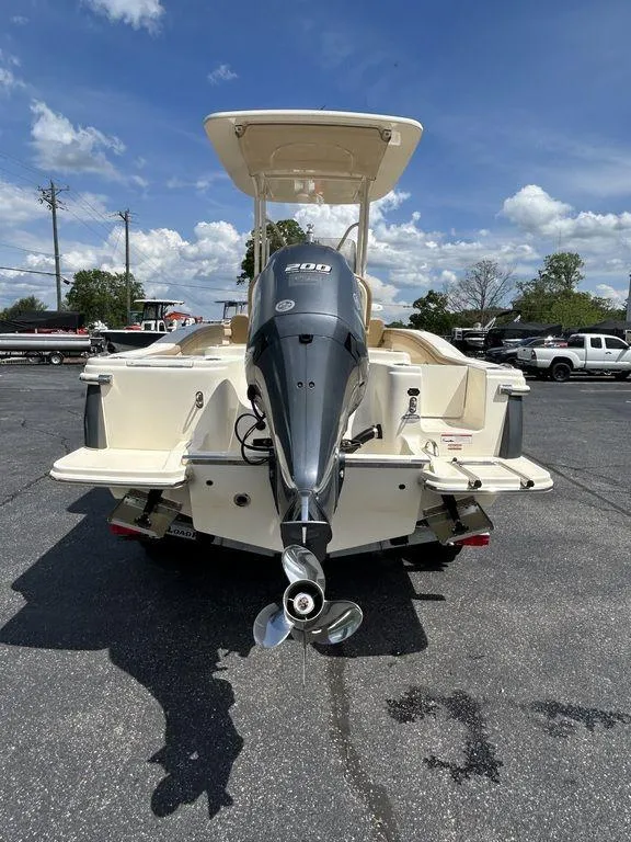 Slide: The Image of 2021 Scout 215 XSF boat with powerful outboard motor, parked on asphalt under blue sky. - 4