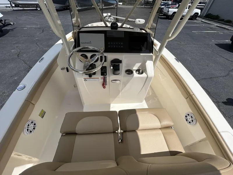 Slide: The Image of 2021 Scout 215 XSF boat interior with steering wheel, beige seating, and control panel. - 7