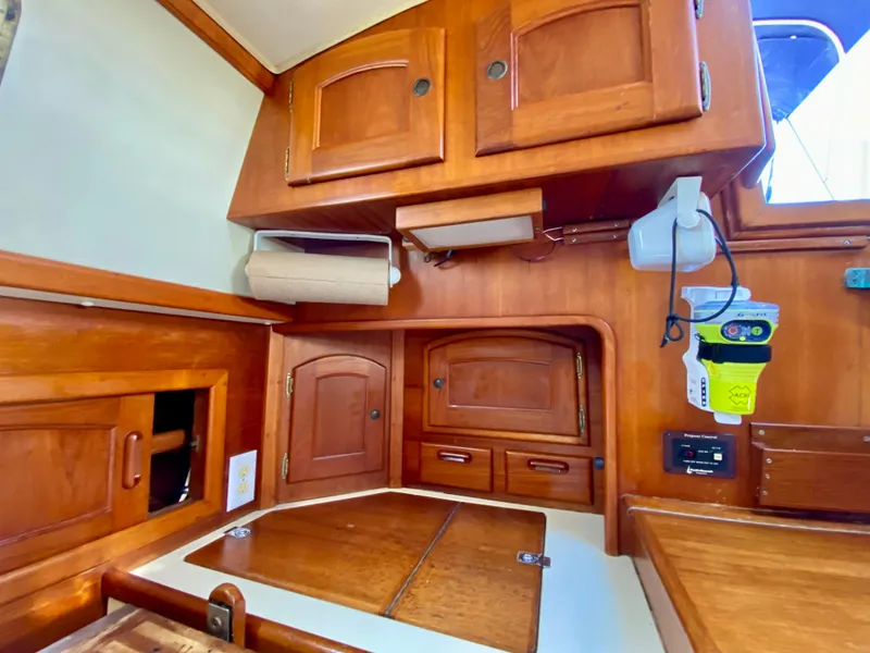 Slide: The Image of Interior of 1998 Pacific Seacraft 37 sailboat with wooden cabinetry and storage compartments. - 18