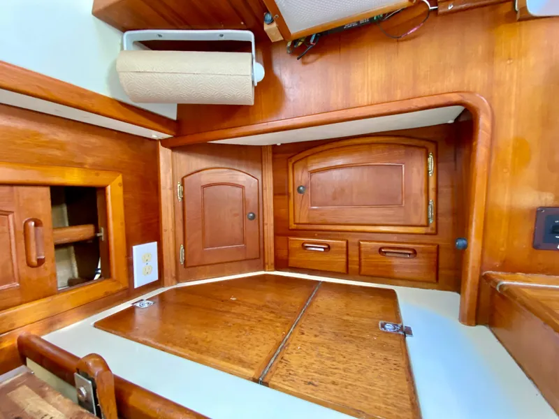 Slide: The Image of Interior of 1998 Pacific Seacraft 37 sailboat with wooden cabinetry and storage compartments. - 19