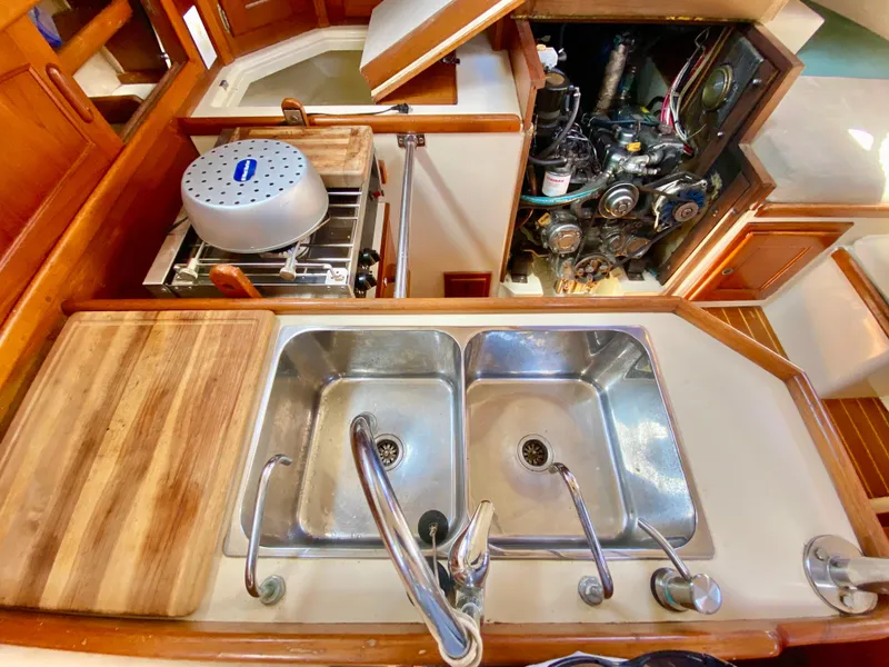 Slide: The Image of Galley of 1998 Pacific Seacraft 37 with dual sinks and visible engine compartment. - 24