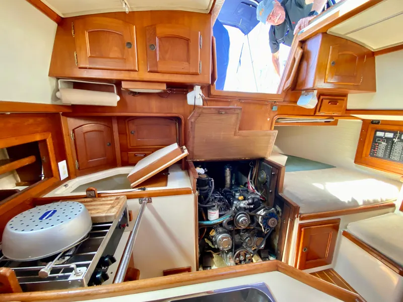 Slide: The Image of Interior of a 1998 Pacific Seacraft 37 sailboat, showcasing engine and wooden cabinetry. - 26
