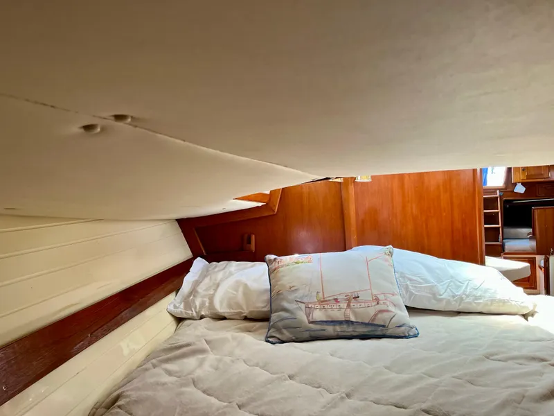 Slide: The Image of Cozy cabin interior of 1998 Pacific Seacraft 37 sailboat with pillows and wooden accents. - 37