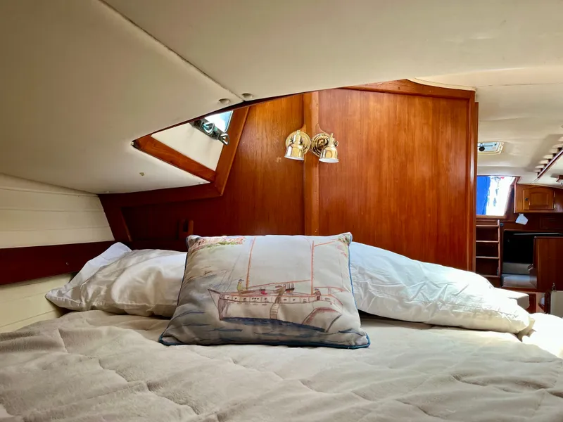 Slide: The Image of Cozy cabin interior of 1998 Pacific Seacraft 37 sailboat with nautical-themed pillow. - 38