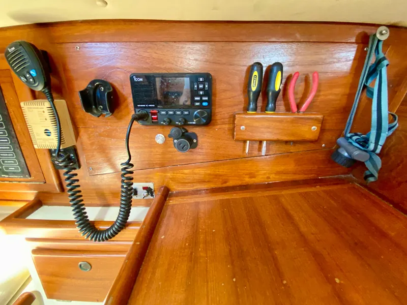 Slide: The Image of Navigation station of 1998 Pacific Seacraft 37 with radio, tools, and wooden paneling. - 40