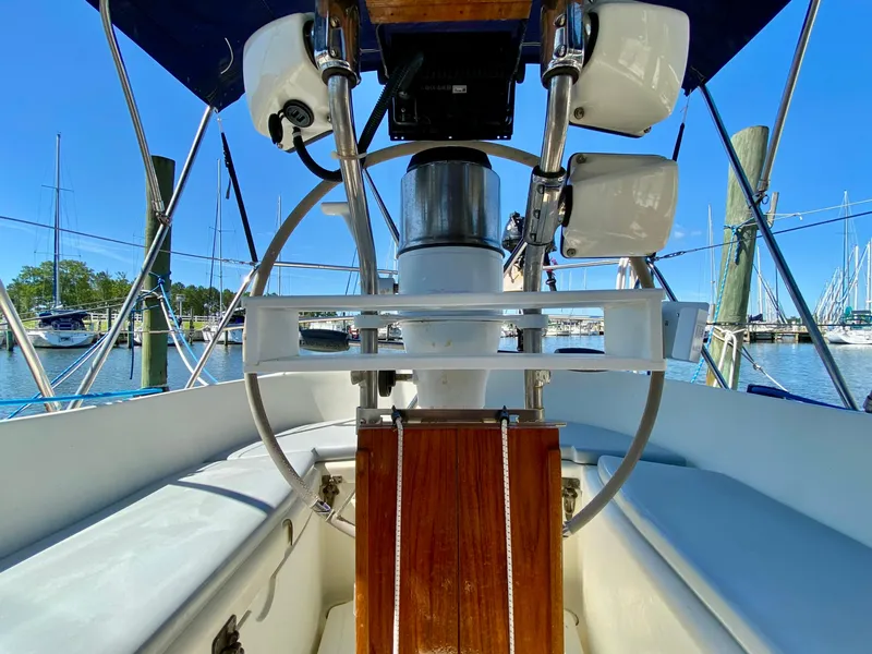Slide: The Image of Cockpit view of 1998 Pacific Seacraft 37 sailboat with steering wheel and marina background. - 7
