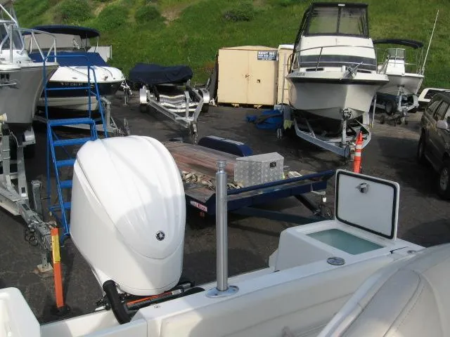 Slide: The Image of 2023 Edgewater 245CC boat in storage yard with other boats and trailers. - 3