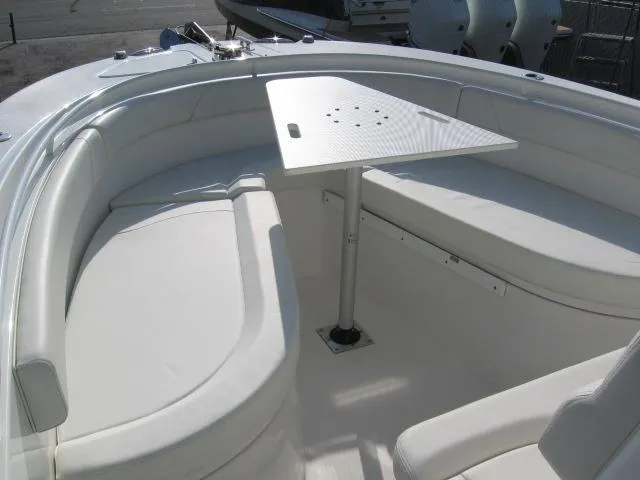 Slide: The Image of 2023 Edgewater 245CC boat interior with white seating and table. - 6