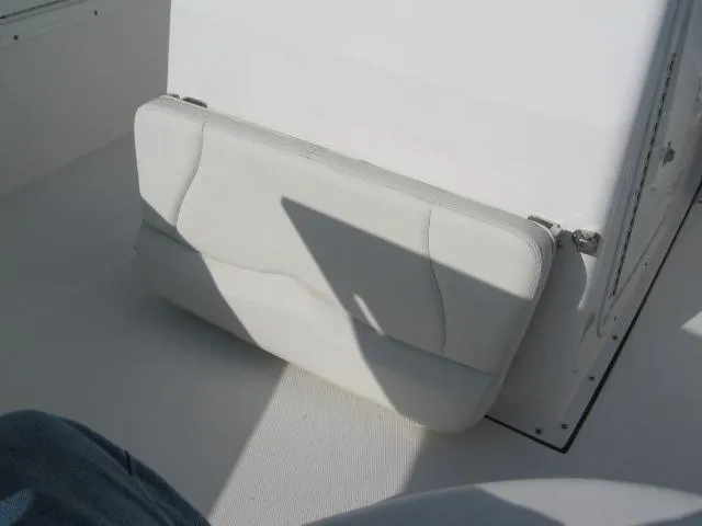 Slide: The Image of 2023 Edgewater 245CC boat seat, white cushion, folded against console. - 8