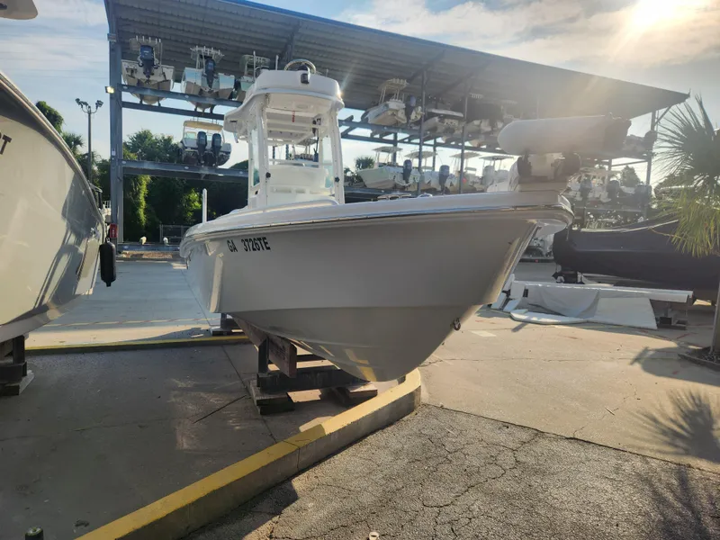 Slide: The Image of 2021 Everglades 243 Center Console boat displayed in a marina under sunlight. - 0