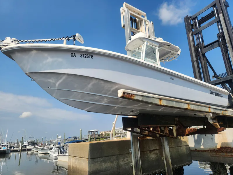 Slide: The Image of 2021 Everglades 243 Center Console boat on lift at marina, clear sky background. - 1