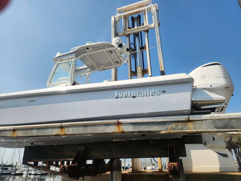 Slide: The Image of 2021 Everglades 243 Center Console boat on a lift at a marina. - 2
