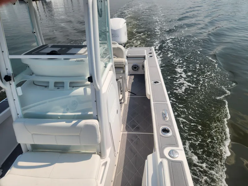 Slide: The Image of 2021 Everglades 243 Center Console boat cruising on water, showcasing sleek design and spacious deck. - 6