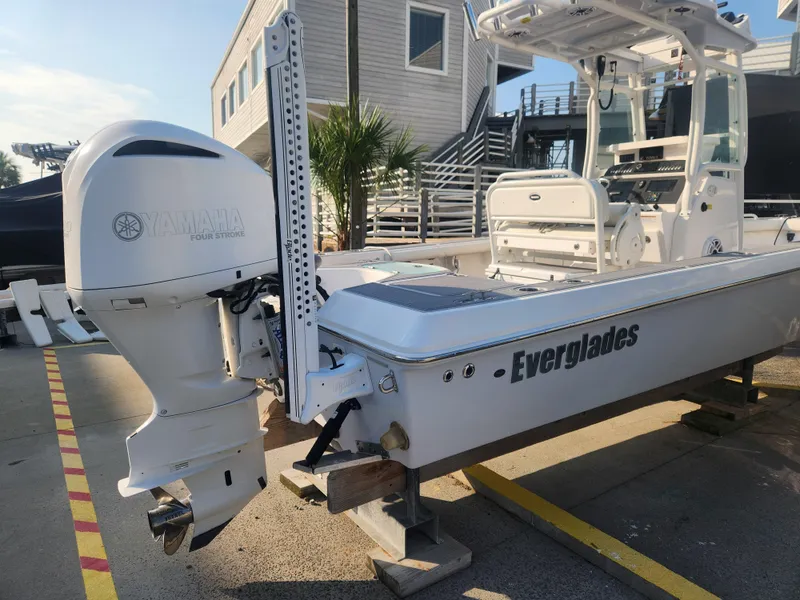 Slide: The Image of 2021 Everglades 243 Center Console boat with Yamaha outboard motor, docked near a modern building. - 7